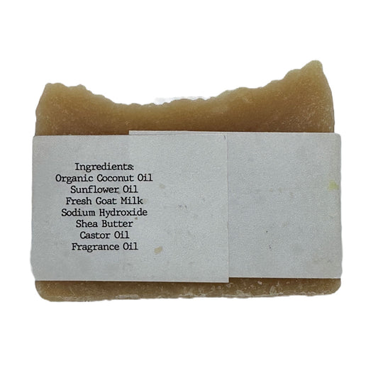 Goat milk soap bar wrapped in white belly band labeled with ingredients list