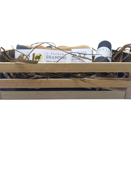 Gift set with soap, shampoo bar, and lotion in a wooden basket on a white background