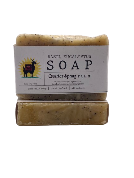 Goat milk soap bar wrapped in white belly band labeled ‘Basil Eucalyptus’ with basil and eucalyptus essential oils