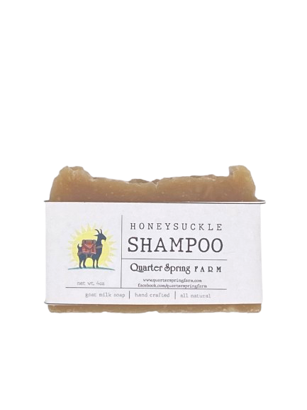 Bar of soap with a label for Honeysuckle Shampoo from Quarter Spring Farm on a white background